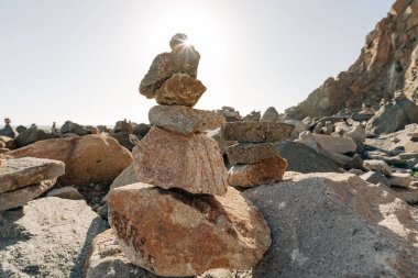 Kaliforniya 'da gün batımında kumsalda taş piramitler. Denge, sükunet, uyum kavramı