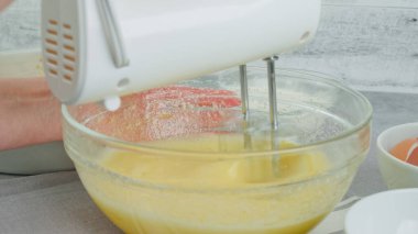 Cake batter in a glass bowl close-up on a kitchen table