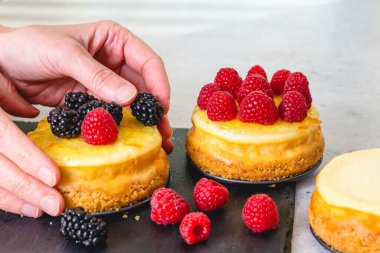 Mini peynirli kekleri taze ahududu ve böğürtlenlerle süslüyorum. Yakın çekim pişirme süreci, ev yapımı cheesecake tarifi