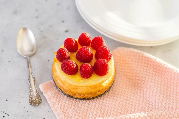Classic mini cheesecake with fresh raspberries. Cheesecake close-up on grey background