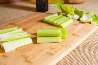 Taze organik kereviz, ahşap kesme tahtasına yakın plan, açık kırsal arka plan.