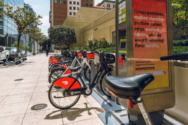 Los Angeles, Kaliforniya, ABD - 25 Nisan 2023. Metro bisikletleri Los Angeles şehir merkezindeki kaldırımda park halindedir. Sokak manzarası, şehir hayatı