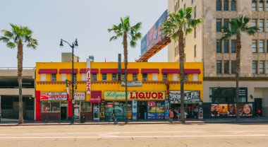 Hollywood, California, ABD - 26 Nisan 2023. Hollywood Bulvarı 'ndaki küçük pizzacı, içki dükkanı ve hediyelik eşya dükkanı, sokak manzarası. Tipik mimari, parlak mağazalar, palmiye ağaçları