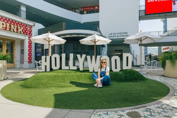 米国カリフォルニア州ロサンゼルス 2023年4月26日 ハリウッドの中心にあるオベーションセンターの緑の芝生の上に座っている幸せな女性は 星からちょうどステップ — ストック写真