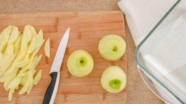 Elma dilimleri, ahşap bir tahta üzerinde kırsal arka planda, düz bir zeminde kapanıyor..