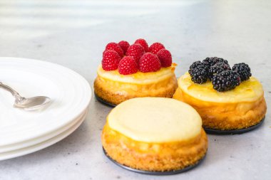 Klasik mini cheesecake tarifi. Açık gri arkaplanda peynirli kekler yakın plan