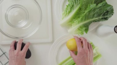 Marul, taze avokado, kereviz ve limonlu zeytinyağı soslu salata tarifi. Malzemeler mutfak masasına yakın çekim, düz yatış