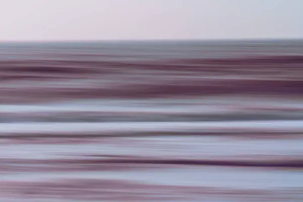 Pink sunset over the sea, abstract seascape, motion blur in light blue and pink colors, copy space