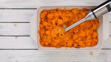 Kızarmış tereyağlı kabak çorbası tarifi, hazırlık süreci. Kızarmış sebzeleri püreye karıştırmak, bir kaseye sebze stoğu eklemek, yakın çekim manzarası.