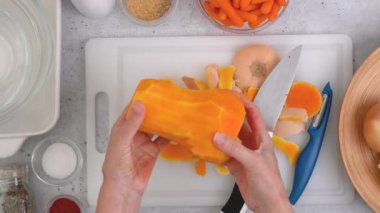 Tereyağlı kabak çorbası tarifi. Mutfak masasının üzerinde çiğ sebzeler. Kabak soyma, hazırlık süreci, kadın eli, düz uzanma.