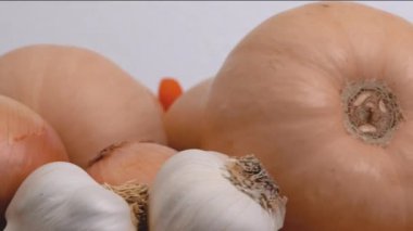 Tereyağlı kabak çorbası tarifi. Mutfak masasının üzerinde çiğ sebzeler. Tahta bir tabakta tereyağlı kabak, havuç, soğan ve sarımsak.