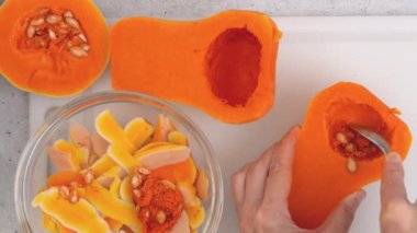 Kabak çorbası tarifi, hazırlık süreci. Çiğ sebzeler ve baharatlar mutfak masasına yakın plan, düz yatak. Kadın elleri kabak soyar, düz uzanır