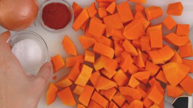 Tereyağlı kabak çorbası tarifi. Mutfak masasındaki kesme tahtasına yakın plan tereyağı ezmesi küpleri.