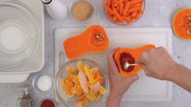 Kabak çorbası tarifi, hazırlık süreci. Çiğ sebzeler ve baharatlar mutfak masasına yakın plan, düz yatak. Kadın elleri kabak soyar, düz uzanır