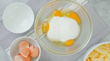 Cam bir kasede yumurta ve şekerin karışımı. Elmalı kek tarifi