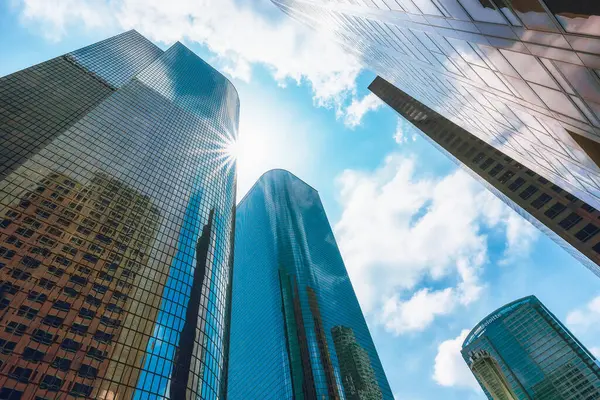 Los Angeles, Kaliforniya, ABD - 25 Nisan 2023. Los Angeles şehir merkezindeki gökdelenler. İş Bölgesi. Arka planda bulutlu bir gökyüzü olan yüksek modern binaların alçak açılı görüntüsü.