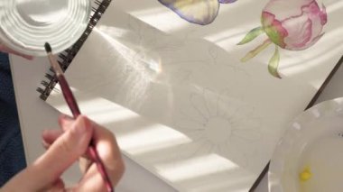 Suluboya resim. Fırçalar ve kâğıtlar pencerenin parlak güneş ışığında bir masanın üzerinde. Sanat, çizim öğrenme, hobi konsepti