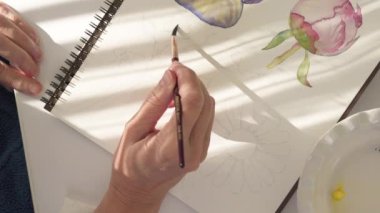Suluboya resim. Fırçalar ve kâğıtlar pencerenin parlak güneş ışığında bir masanın üzerinde. Sanat, çizim öğrenme, hobi konsepti