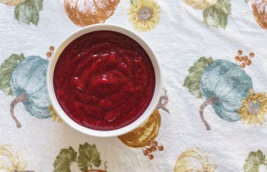 Böğürtlen sosu beyaz bir kasede yakın plan bir masada, düz bir yerde fotokopi alanı ile.