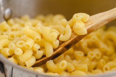 Tencerede makarna pişirdim. Bir kaşık makarna yakın plan pişirme kabında.