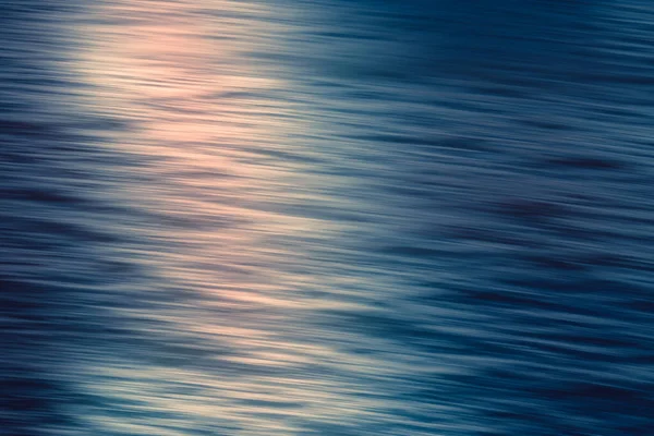 Abstract seascape. Beautiful pink sunset over the Pacific ocean, motion blur, soft light