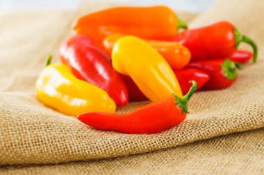 Fresh sweet peppers assortment. Red pepper, yellow pepper, orange pepper close-up on a rustic backgrpund