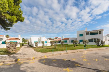 Canlı bir turistik bölgede, güzel bulutlu gökyüzünün altında el değmemiş beyaz apartman daireleriyle dolu bir cadde..