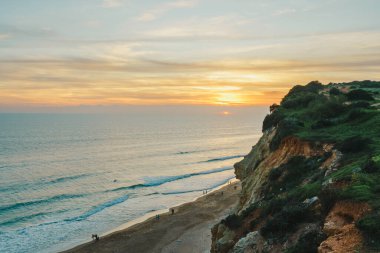 Muhteşem okyanus manzarası ve bulutlu gökyüzü ile görkemli uçurumların üzerinde nefes kesici bir gün batımı.