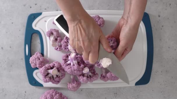女性は紫色のカリフラワーを小花に入れ 調理プロセス 上からの眺め — ストック動画