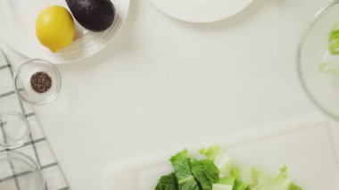 Marul, taze avokado, kereviz ve limonlu zeytinyağı soslu salata tarifi. Malzemeler mutfak masasına yakın çekim, düz yatış