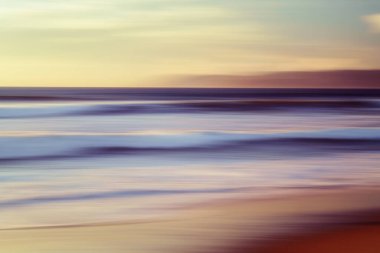 Pembe günbatımı. Bulanık hareketli soyut deniz manzarası. Güneşin doğuşu ya da batışı, güzel yumuşak ışık, kırmızı ve pembe renkler.