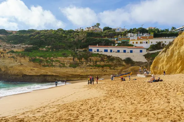 Sahile gidenler, Algarve 'ın kayalık evlerinin altındaki geniş kumların tadını çıkarıyorlar. Algarve, Portekiz, 2 Ocak 2024