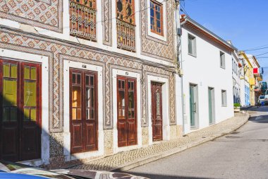 Portekiz 'in Nazare şehrinde bir caddede azulejo fayans cepheli geleneksel Portekiz binaları hizalanır..