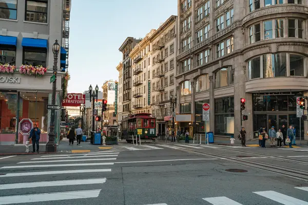 San Francisco, Kaliforniya, 8 Nisan 2024. San Francisco 'nun işlek caddesi boyunca tarihi binalar tarafından çevrelenmiş olan raylardan araç yaklaşıyor..