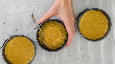 Peynirli kek tarifi için kraker kabuğu. Ev yapımı mini cheesecake hazırlama süreci, yakın çekim malzemeleri.