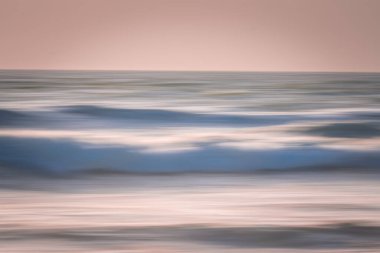 Deniz üzerinde pembe günbatımı soyut. Hafif deniz manzarası, açık gökyüzü pembe renkli, hareket bulanıklığı, metin için boşluk kopyala