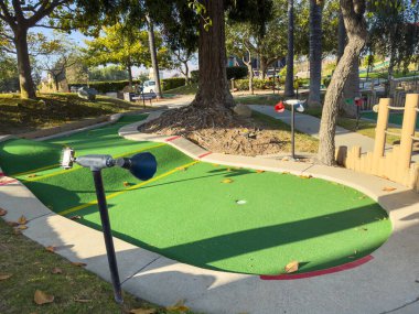 Renkli mini golf sahasında çeşitli delikler ve eğlenceli zorluklar var..