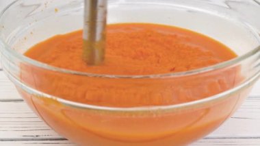 Kızarmış tereyağlı kabak çorbası tarifi, hazırlık süreci. Kızarmış sebzeleri püreye karıştırmak, bir kaseye sebze stoğu eklemek, yakın çekim manzarası.