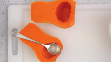 Kabak çorbası tarifi, hazırlık süreci. Çiğ sebzeler ve baharatlar mutfak masasına yakın plan, düz yatak. Kadın elleri kabak soyar, düz uzanır