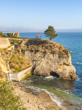 Uçurum kenarındaki balkon okyanusa bakıyor. Aşağıda tenha bir plaj var..