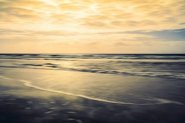 Sahilde gün batımı, soyut deniz manzarası, hareket bulanıklığı.