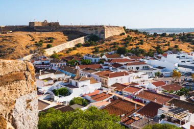 Portekiz, Castro Marim 'deki parlak güneşin altında kale duvarları ve büyüleyici köy çatıları..