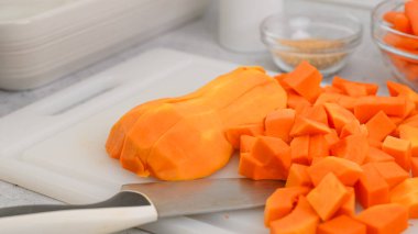 Tereyağlı kabak çorbası tarifi. Mutfak masasının üzerinde çiğ sebzeler. Kabuğu soyulmuş ve çekirdeksiz kabak kesme tahtasına yakın çekim, düz yatış