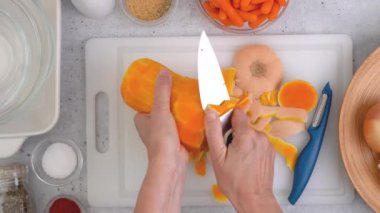 Tereyağlı kabak çorbası tarifi. Mutfak masasının üzerinde çiğ sebzeler. Kabak soyma, hazırlık süreci, kadın eli, düz uzanma.