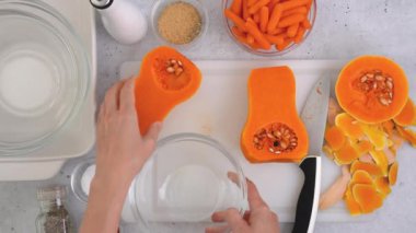 Kabak çorbası tarifi, hazırlık süreci. Çiğ sebzeler ve baharatlar mutfak masasına yakın plan, düz yatak. Kadın elleri kabak soyar, düz uzanır