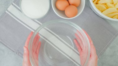 Apple cake recipe. Ingredients for baking needs close-up on a kitchen table, woman hands, flat lay