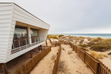 Sahile bakan modern restoranlar kumlu kumullara ve okyanusa bakıyor..