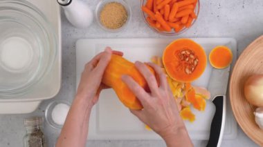 Tereyağlı kabak çorbası tarifi. Mutfak masasının üzerinde çiğ sebzeler. Kabak soyma, hazırlık süreci, kadın eli, düz uzanma.