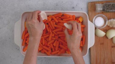 Kızarmış tereyağlı kabak çorbası tarifi. Soyulmuş ve çekirdeksiz kabak küpleri, havuç, soğan, sarımsak ve baharatlar mutfak masasındaki seramik fırın kabında yakın plan.