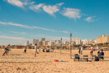 Portimao, Portekiz, 18 Ocak 2025. İnsanlar kumlu kortlarda okyanusun yakınındaki güneşli mavi gökyüzünün altında tenis oynuyorlar..